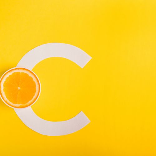 Slice of orange forming part of a large letter C on a yellow background