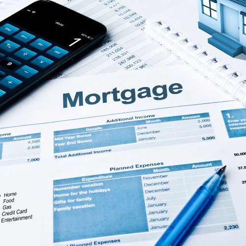 Mortgage budget spreadsheet with a calculator, phone and pen