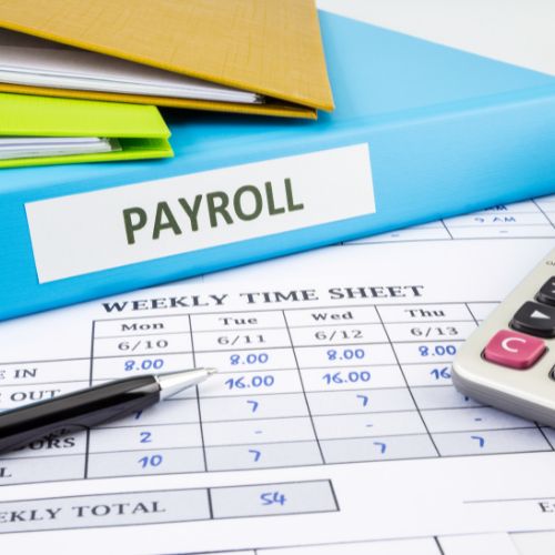 Payroll folder, weekly time sheet and calculator on a desk