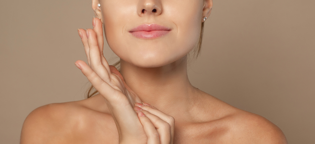 Woman resting her hands beside her face against a beige background