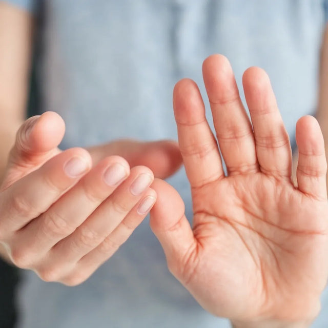Open palm of a hand held up against a pale blue background