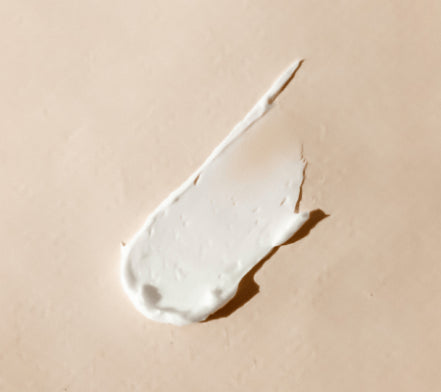 Smear of white cream on a beige background